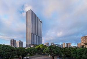ein großer Wolkenkratzer mitten in einer Stadt in der Unterkunft Waldorf Astoria Xiamen in Xiamen