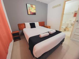 a bedroom with a large white bed with two pillows at Hotel Dulce Luna in San Cristóbal de Las Casas