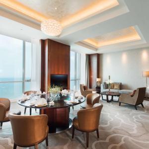 a hotel lobby with tables and chairs and a couch at Hilton Yantai Golden Coast in Yantai