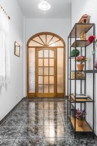 a room with a door and a shelf with flowers at Raíces Vivas Vivienda Vacacional in Vega de San Mateo