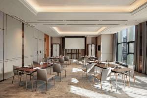 a conference room with tables and chairs and a projection screen at Doubletree By Hilton Yangzhou in Yangzhou