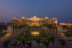 a large building with a fountain in front of it at Hilton Haikou Meilan in Haikou