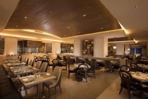 a restaurant with tables and chairs and a bar at Hilton Haikou Meilan in Haikou