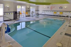 a swimming pool with blue water and yellow chairs at Fairfield Inn & Suites Kingsland in Kingsland