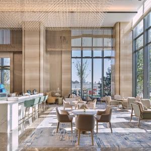 a restaurant with tables and chairs and large windows at Hilton Beijing Tongzhou in Beijing