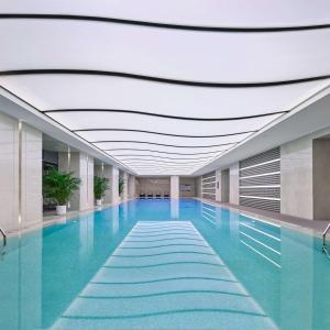 a swimming pool with blue water in a building at Hilton Beijing Tongzhou in Beijing