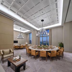 a dining room with tables and chairs and chandeliers at Hilton Beijing Tongzhou in Beijing
