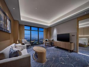a living room with a couch and a television at Hilton Beijing Tongzhou in Beijing