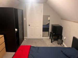 Dormitorio con puerta blanca, cama y TV en Guest House, en Winnipeg