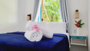 uma cama com dois bichos de peluche sentados nela em Casa Linda Boipeba na Ilha de Boipeba