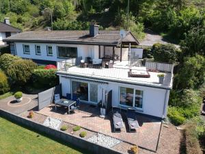 an aerial view of a house with a patio at Exklusives Ferienhaus "Agger-Blick" mit riesiger Seeblick-Terrasse, Sauna, E-Kamin & Kajak in Gummersbach