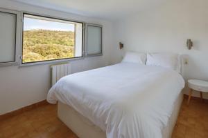 una camera da letto con un grande letto bianco e una finestra di Cosy Gîte in Gabian with Beautiful River and Vineyard Views a Gabian