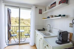 a kitchen with a sink and a balcony at Cosy Gîte in Gabian with Beautiful River and Vineyard Views in Gabian