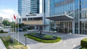 Shunde佛山顺德海俊达希尔顿酒店-广交会免费穿梭巴士的街道中间有雕像的建筑