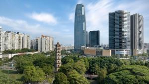 um horizonte da cidade com edifícios altos e árvores em Hilton Foshan Shunde - Free Canton Fair Shuttle Bus em Shunde