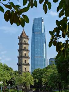 a tall building in front of a city at Hilton Foshan Shunde - Free Canton Fair Shuttle Bus in Shunde