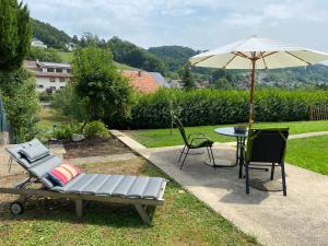 a patio with an umbrella and a table and chairs at Ferienwohnung am Liederbach in Waldshut-Tiengen