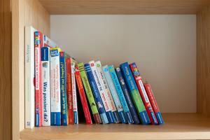 a row of books sitting on a book shelf at Ferienhaus Bergblick Bregenzerwald in Bregenz