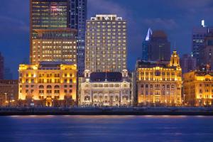 un grupo de edificios en una ciudad por la noche en Waldorf Astoria Shanghai on the Bund, en Shanghái