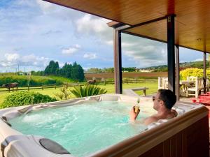 a man in a bath tub with a bottle of champagne at Heaven's Rest B&B in Pukekohe East