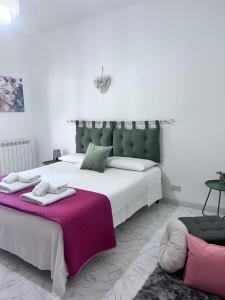 sypialnia z dużym białym łóżkiem i fioletowym kocem w obiekcie Appartamento il sole 2 piano w mieście Realmonte