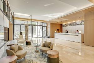 a lobby of a hotel with two chairs and a counter at DoubleTree by Hilton Taipei Zhongshan in Taipei