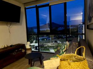 uma sala de estar com um sofá e uma grande janela em Departamento Lago de Chapala con Roof Top. em Jocotepec