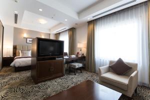 a hotel room with a television and a bed at ANA Crowne Plaza Yonago, an IHG Hotel in Yonago