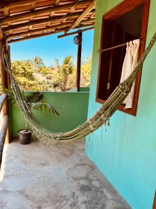 a hammock hanging outside of a house at Pousada Clara in Caraíva