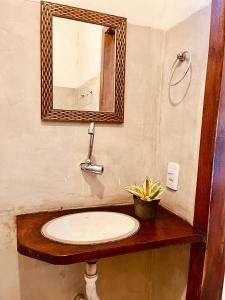 a bathroom with a sink and a mirror at Pousada Clara Caraíva in Caraíva