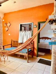 a hammock in a room with a bedroom at Pousada Clara Caraíva in Caraíva