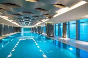 - une piscine avec plafond dans un bâtiment dans l'établissement Hilton Shijiazhuang, à Shijiazhuang