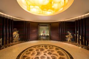 a hallway with a large chandelier and a circular rug at Hilton Shijiazhuang in Shijiazhuang
