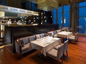 a restaurant with white tables and chairs and a bar at Hilton Shijiazhuang in Shijiazhuang