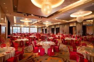 a large banquet hall with tables and red chairs at Hilton Shijiazhuang in Shijiazhuang