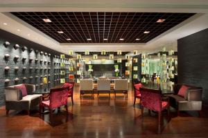 a dining room with a table and chairs and a wall of wine bottles at Hilton Shijiazhuang in Shijiazhuang +64 photos