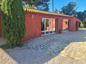 a red house with glass doors and a tree at Villa Allegra T2 60M2 in Le Beausset +5 photos