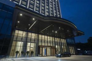 a building with a car parked in front of it at DoubleTree By Hilton Shenzhen Nanshan Hotel & Residences in Shenzhen