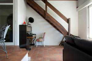 a living room with a staircase and a piano at Retreat Lodge Schürmatt -Leben wie SchweizerInnen in Günsberg  