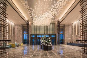 a lobby of a building with a chandelier at Doubletree By Hilton Qingdao Oriental Movie Metropolis in Huangdao