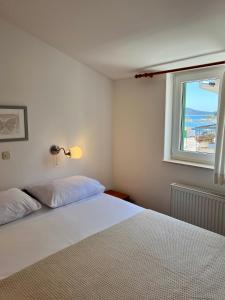 Villa Adria في فوديس: غرفة نوم بسرير ابيض ونافذة