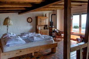 um quarto com uma cama grande e lençóis brancos em Retreat Lodge Schürmatt -Leben wie SchweizerInnen em Günsberg  