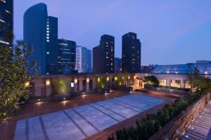 einen Dachgarten mit einer Skyline der Stadt in der Nacht in der Unterkunft Hilton Beijing in Peking