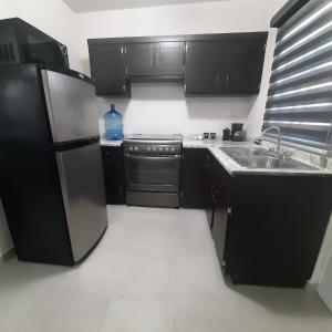a kitchen with a stainless steel refrigerator and a sink at Hospedaje en Salamanca Residencial in Hermosillo