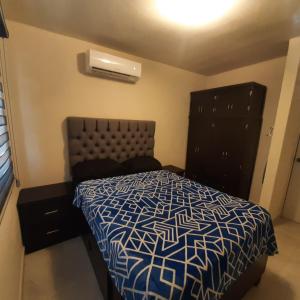 een slaapkamer met een bed en een dressoir bij Hospedaje en Salamanca Residencial in Hermosillo