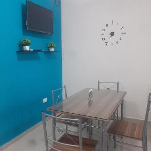 埃莫西約的住宿－Hospedaje en Salamanca Residencial，餐桌、椅子和墙上的时钟