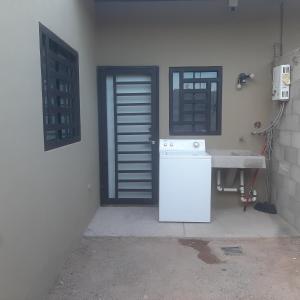 - une cuisine avec un réfrigérateur blanc à côté d'une porte dans l'établissement Hospedaje en Salamanca Residencial, à Hermosillo