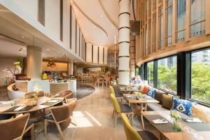 a restaurant with wooden tables and chairs and windows at Hilton Beijing in Beijing
