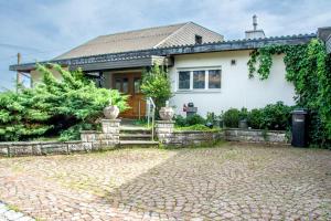 ein weißes Haus mit einer steinernen Einfahrt in der Unterkunft Retreat Lodge Schürmatt -Leben wie SchweizerInnen in Günsberg  