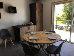 a dining room with a wooden table and chairs at Les Piroulards in Dompierre-les-Tilleuls